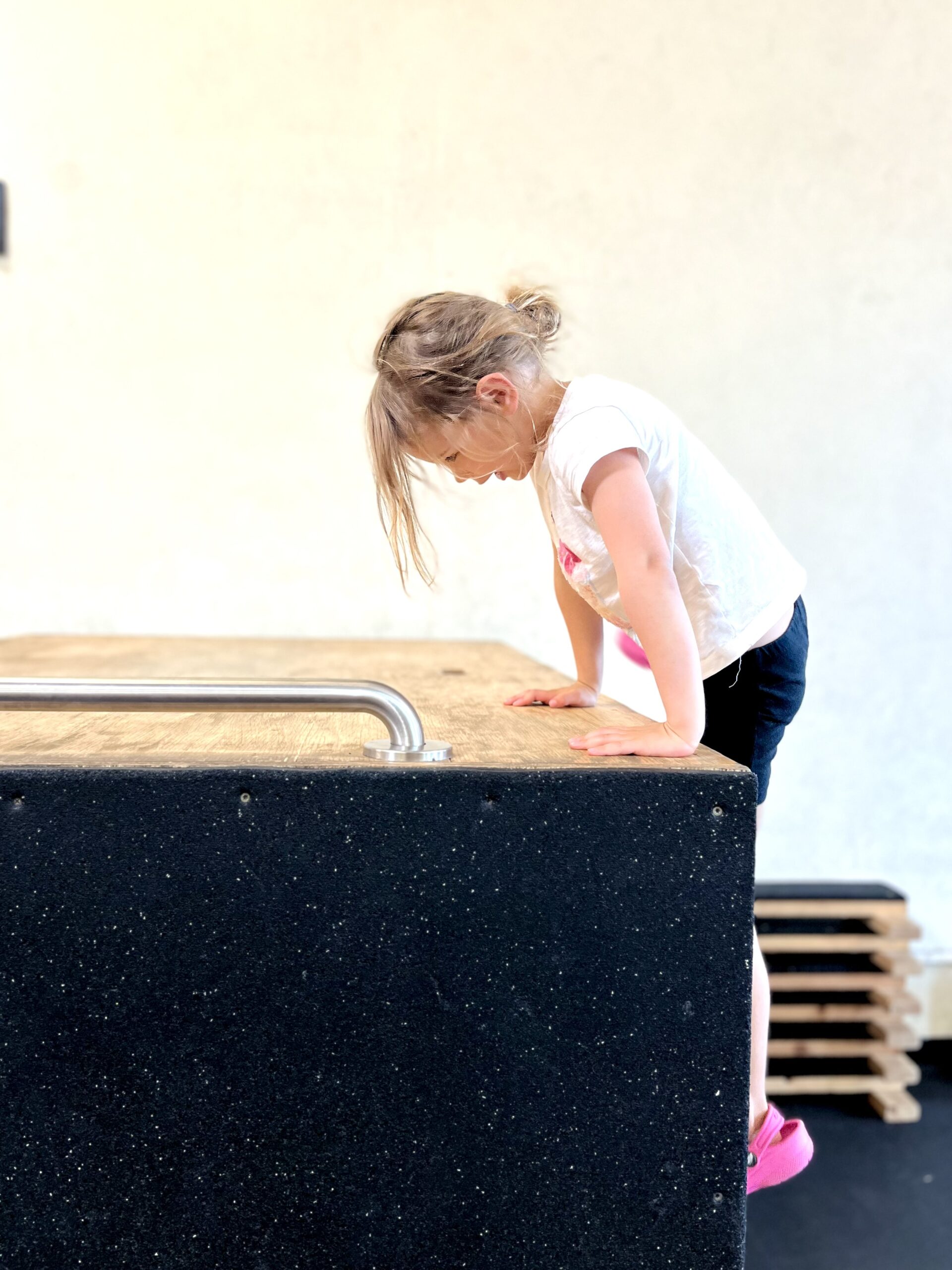 A young Lil' Leaps student climbing onto a parkour obstacle